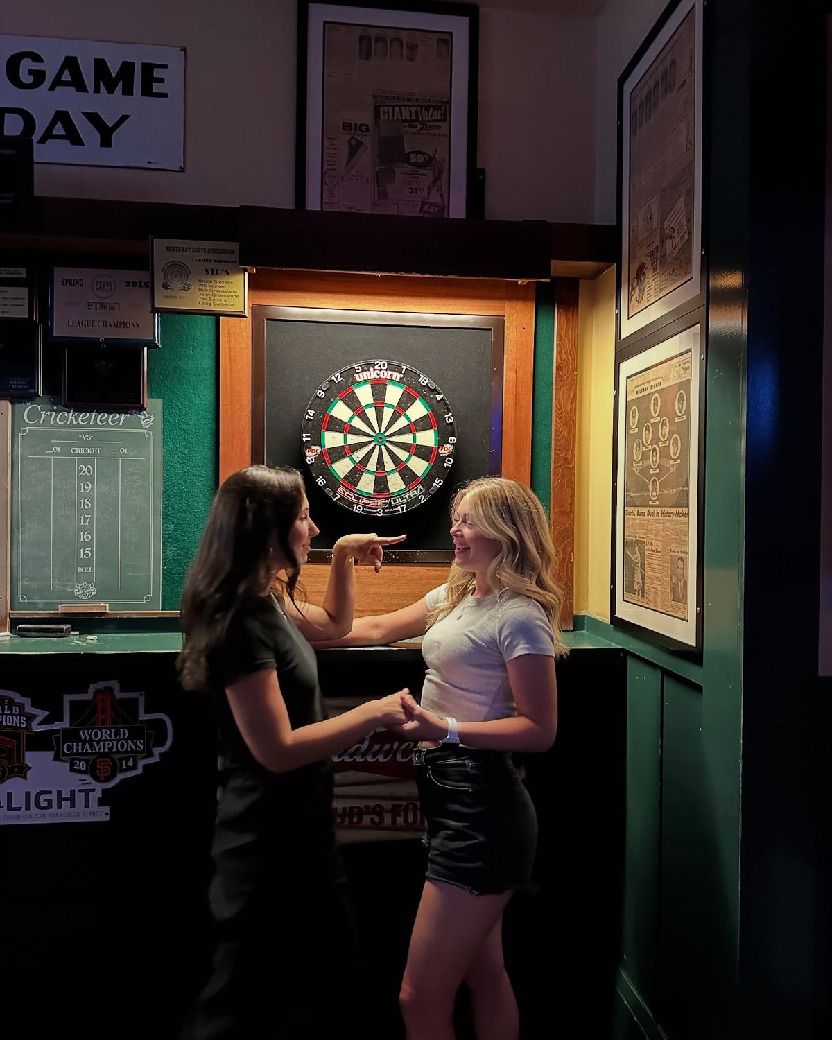 Friends chatting by a dartboard